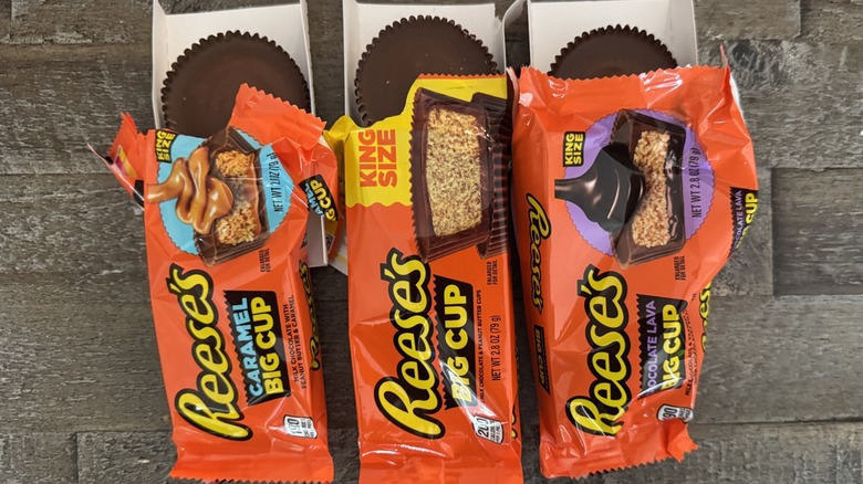 Three Reese's Big Cups on a wooden board with the cups exposedhttps://www.tastingtable.com/1199667/the-long-established-connection-between-hershey-and-reeses