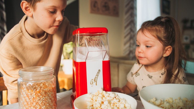 Children watching popcorn machine