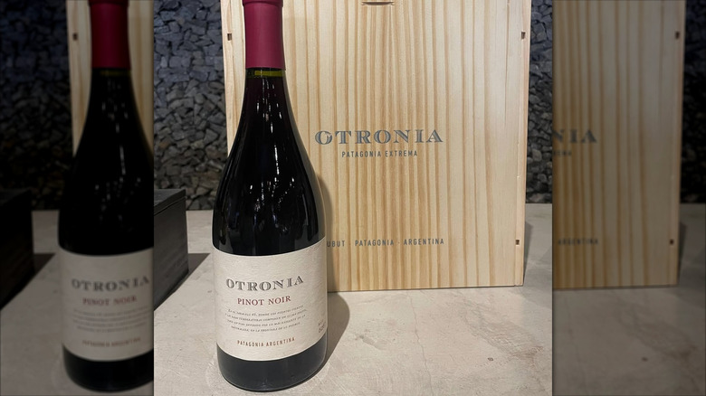 A bottle of Otronia pinot noir alongside its wooden box