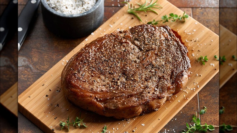 Seasoned steak on wood block