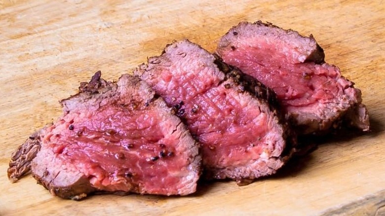 Rare sliced steak on board