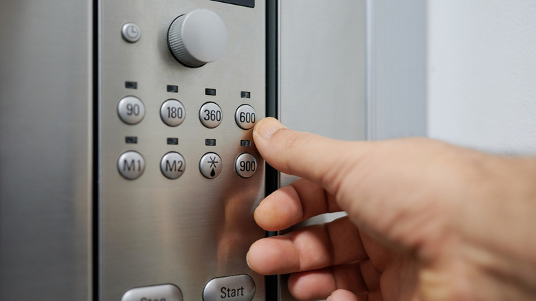 Hand near microwave power buttons