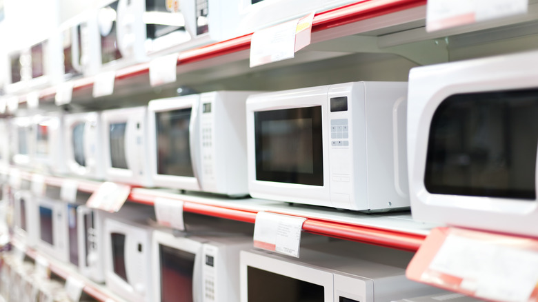 Rows of white microwaves on store shelves