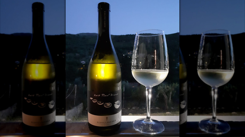 bottle and glass of white wine against evening backdrop