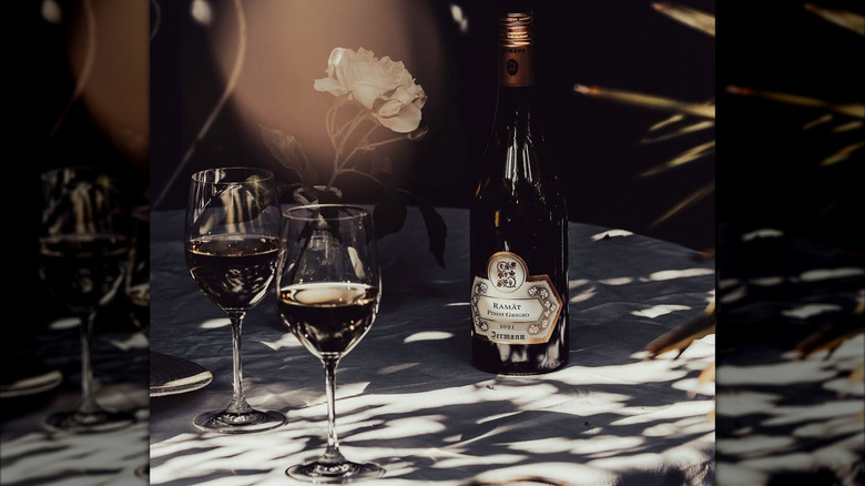 bottle of ramato wine with two glasses and rose flower