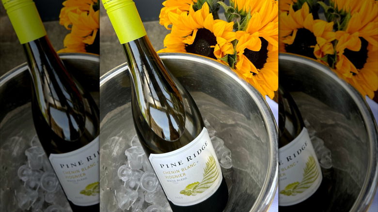 bottle of white wine in ice bucket with sunflowers