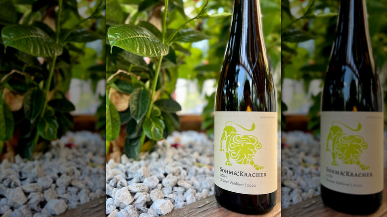 bottle of white wine with pebbles and greenery