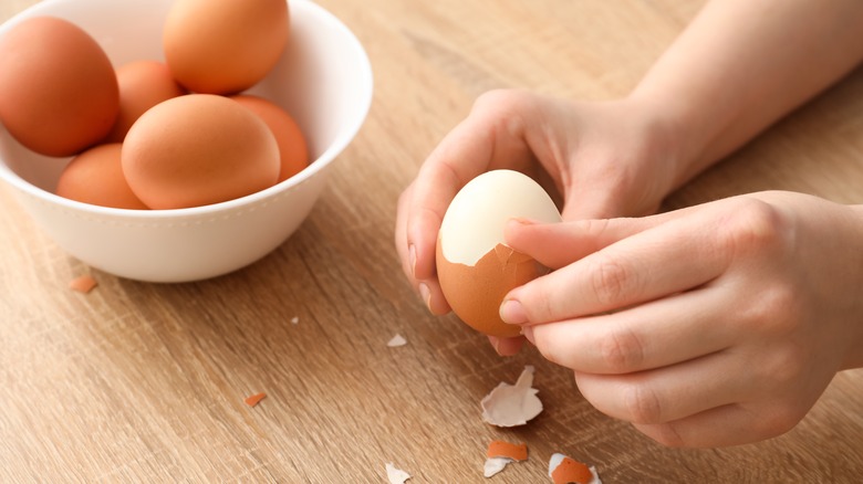 hand peeling boiled eggs