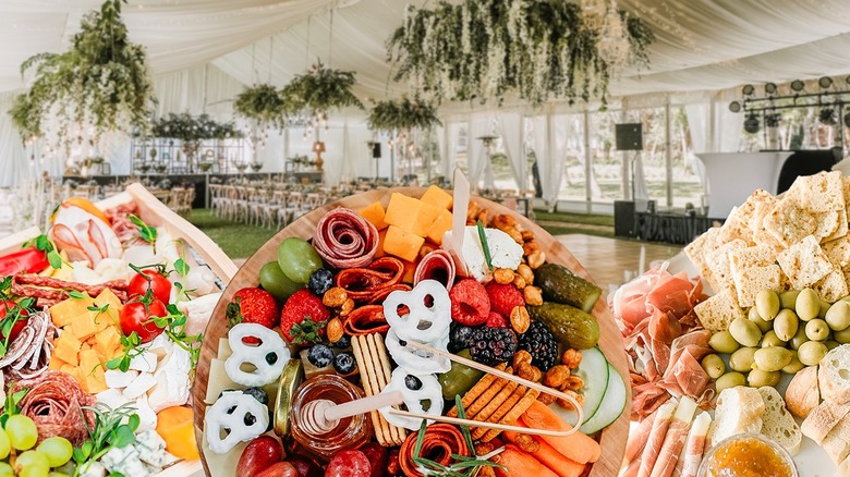 charcuterie boards boards filled with meats, cheeses, and snacks in front of wedding venue