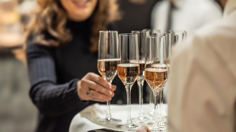 Person getting champagne from a serving tray at a wedding