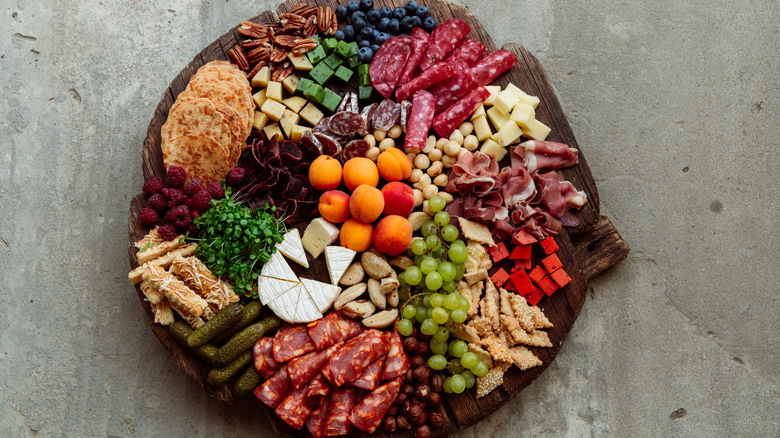 Charcuterie board with fruits, cheese, nuts, and meat