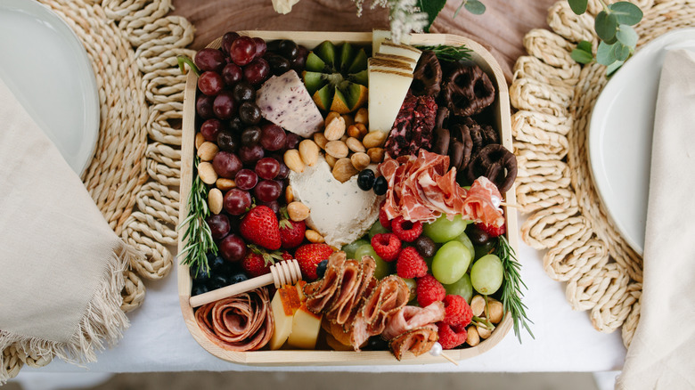 Wedding charcuterie with nuts, meat, and chocolate covered pretzels laid out on elegant table