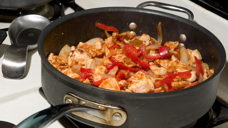 Chicken thighs cooking with vegetables