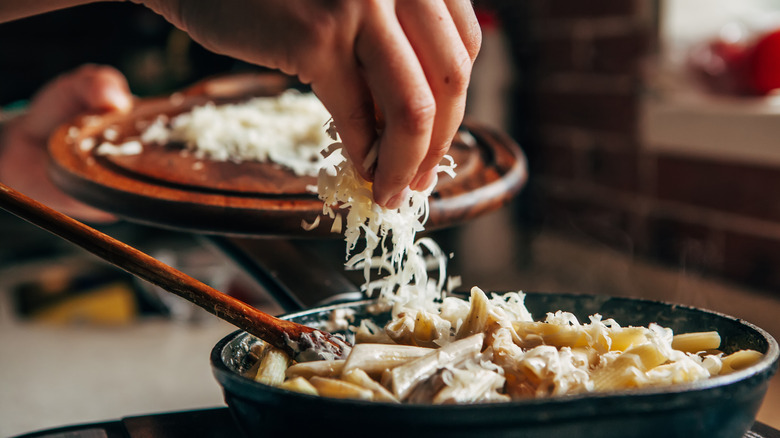 Sprinkling freshly grated cheese on pasta