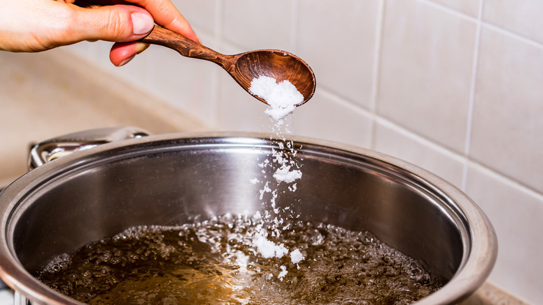 Adding baking soda to a pot of boiling water