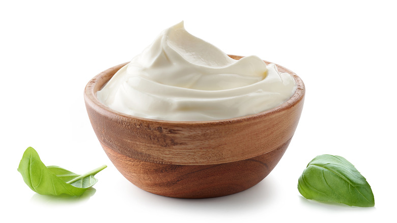 Sour cream in wooden bowl