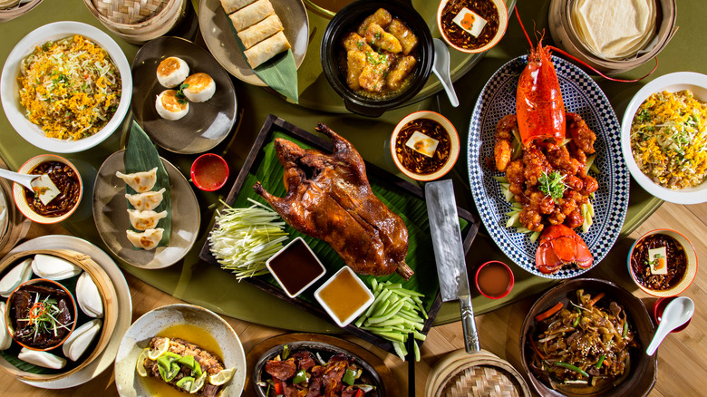 table filled with Chinese food duck bao rice lobster stir fry