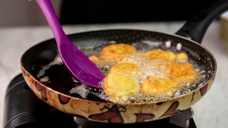 Potatoes frying in shallow pan