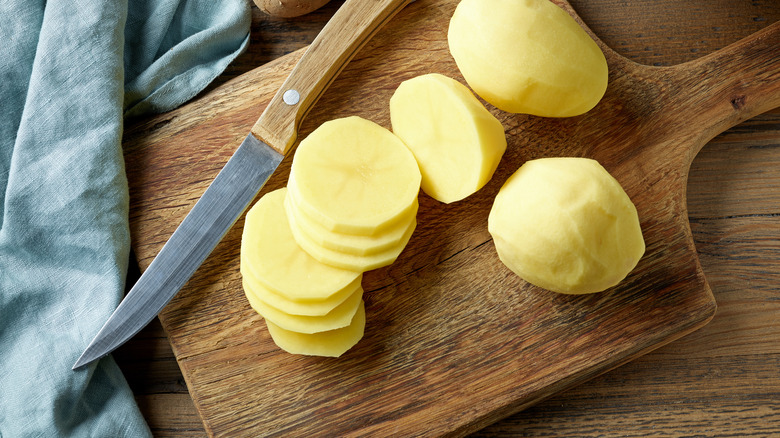 Sliced potatoes on a wooden board