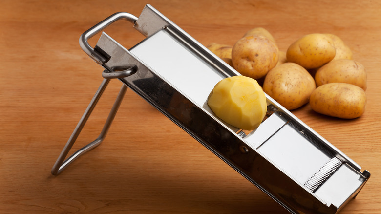 Half a potato on a mandoline slicer