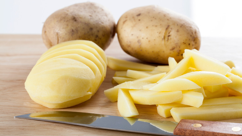 A knife with sliced potatoes