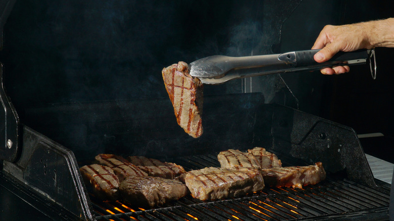 flipping steak with tongs