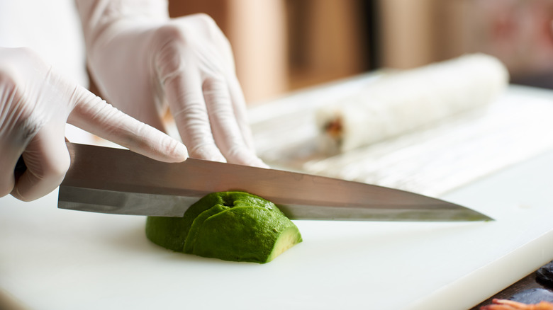 Avocado sliced with metal knife