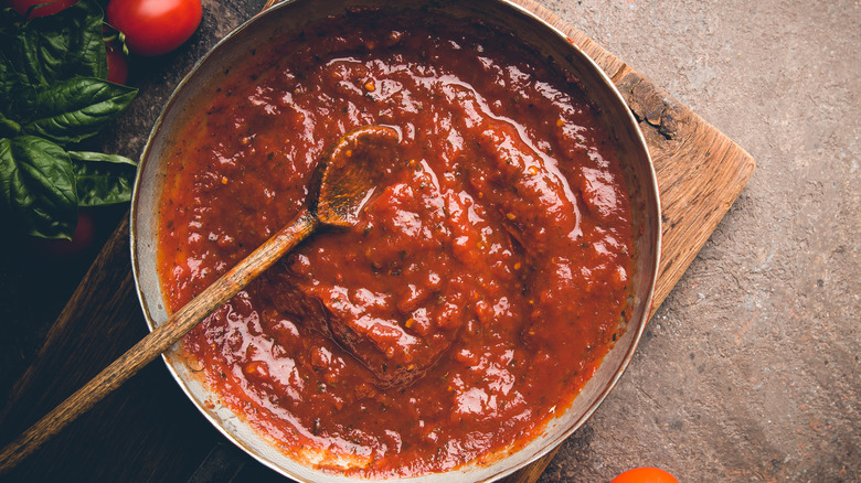 Tomato sauce in pan with spoon