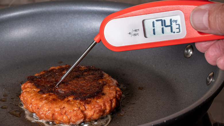 Burger cooking with thermometer