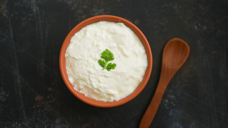 Sour cream in wooden bowl