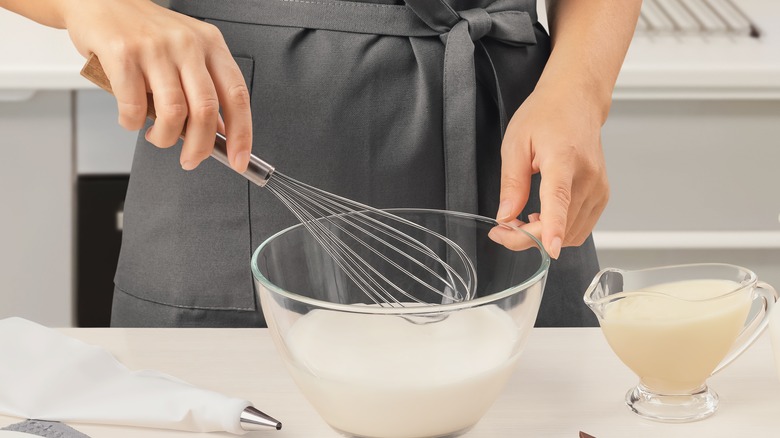 Yogurt in glass bowl with whisk