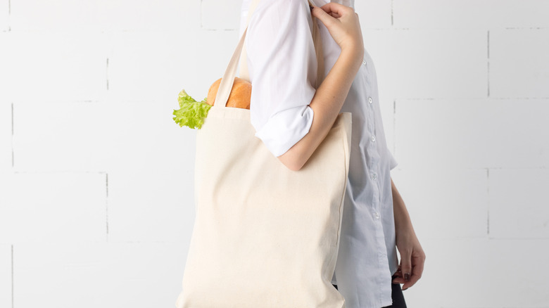 Person holding tote with groceries