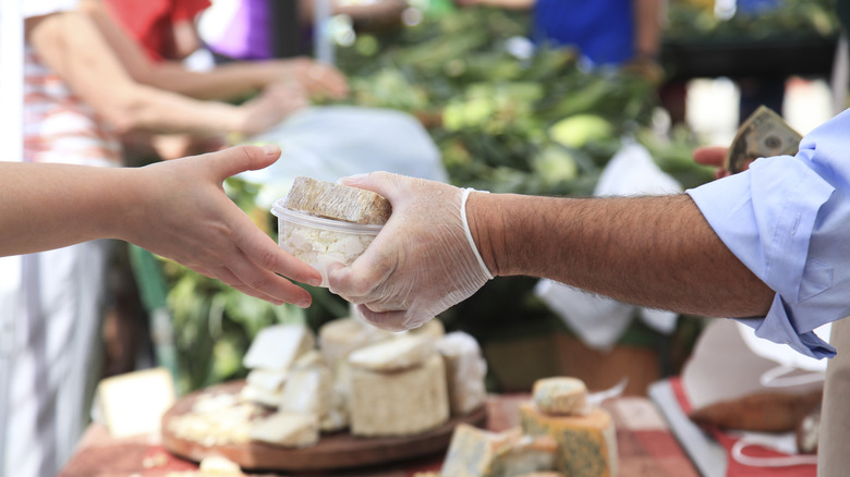 Person handing cheese over