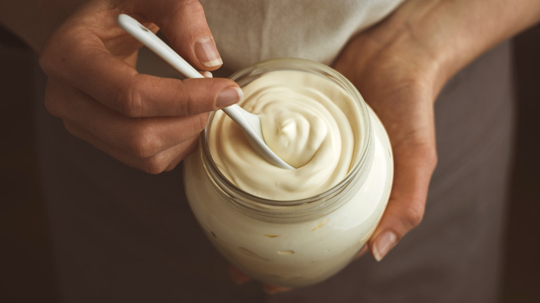 person holding jar or mayonnaise 