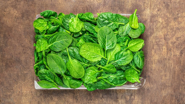 container of spinach on table