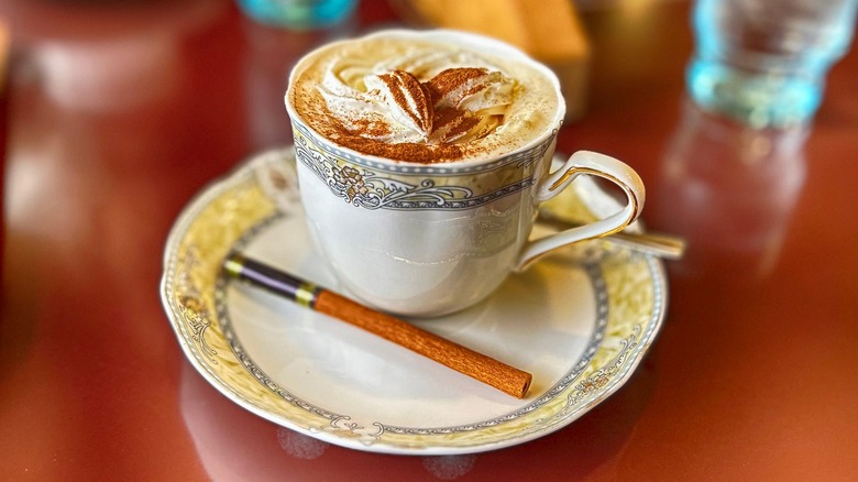 An elegant cream coffee with a cinnamon stick in a kissaten, or Japanese tea and coffee shop