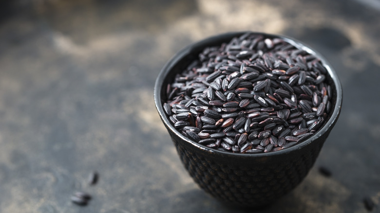 Black bowl of uncooked black rice