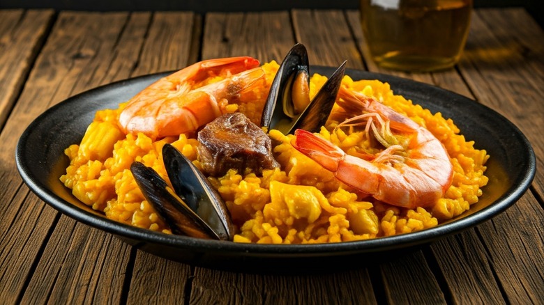 A plate of seafood paella on a wooden table