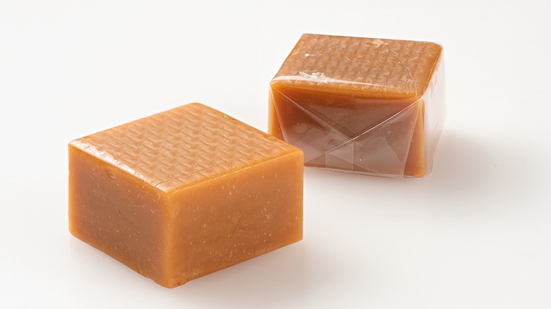 Two squares of toffee on white background