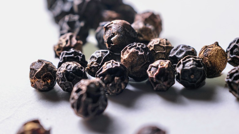 black peppercorns on gray background