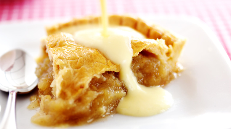 Pouring crème anglaise on apple pie