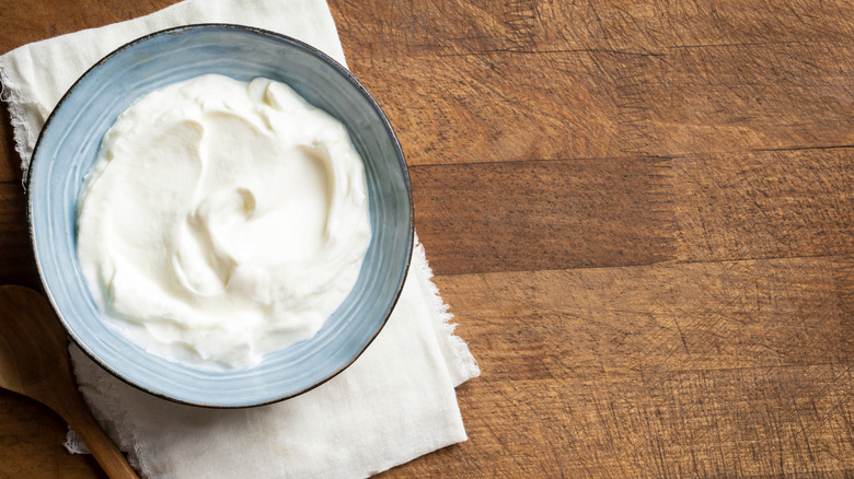 Sour cream in a bowl on wooden surface