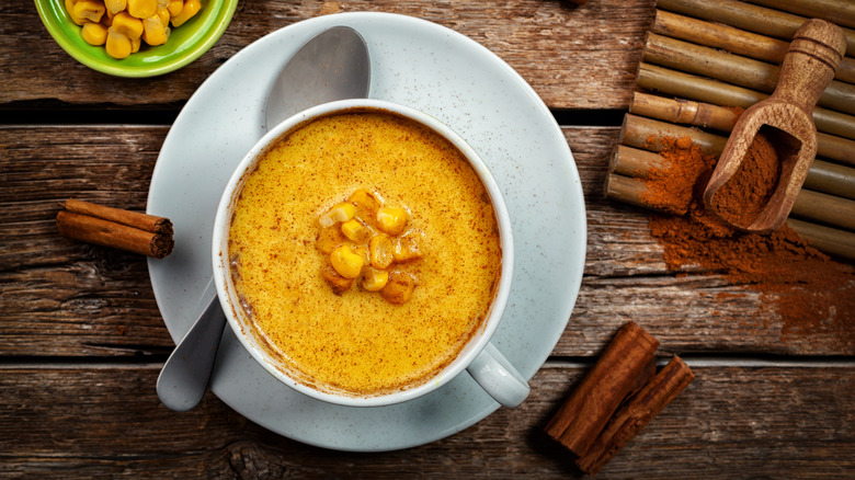 Warm atole corn drink in coffee mug with spoon