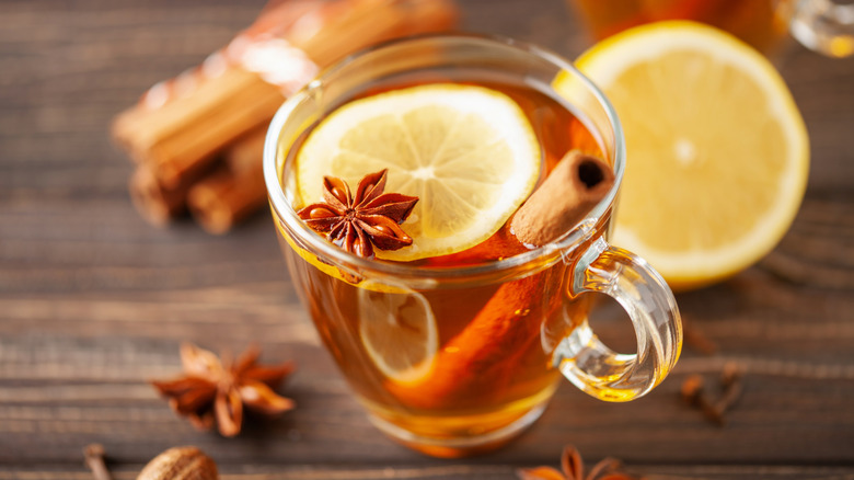 Warm spiced hot toddy with lemon slices and cinnamon