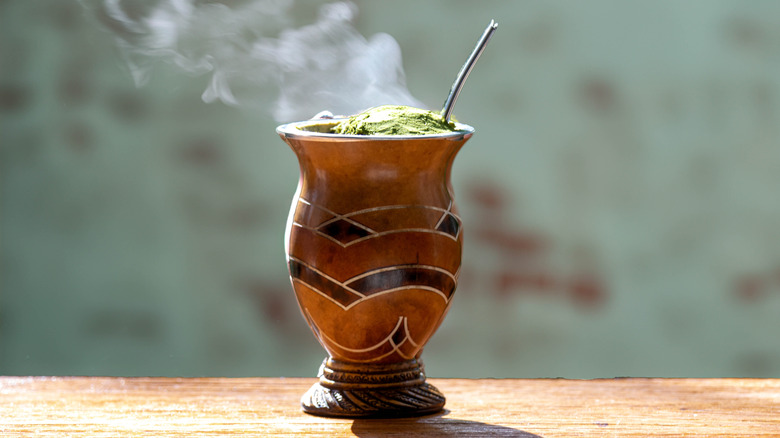 Hot cup of yerba maté tea on wooden table