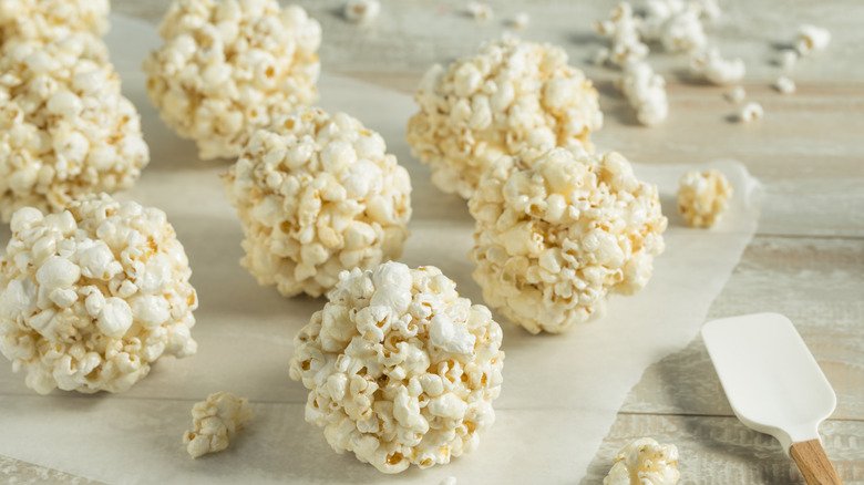 Popcorn balls resting on wax paper on grey table
