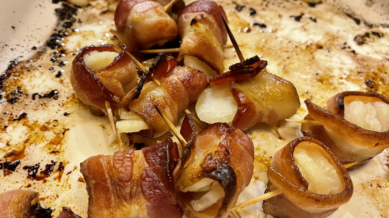 Close-up of rumaki on sauce-splattered dish