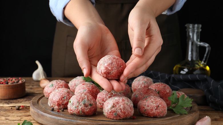 Hands making meatballs