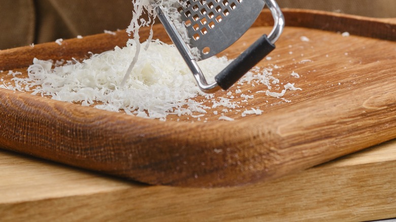 grating Parmesan cheese onto cutting board