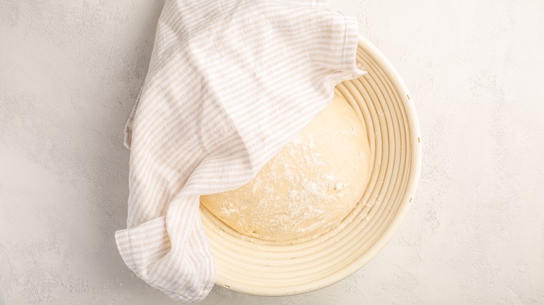 Dough in a basket covered with a towel